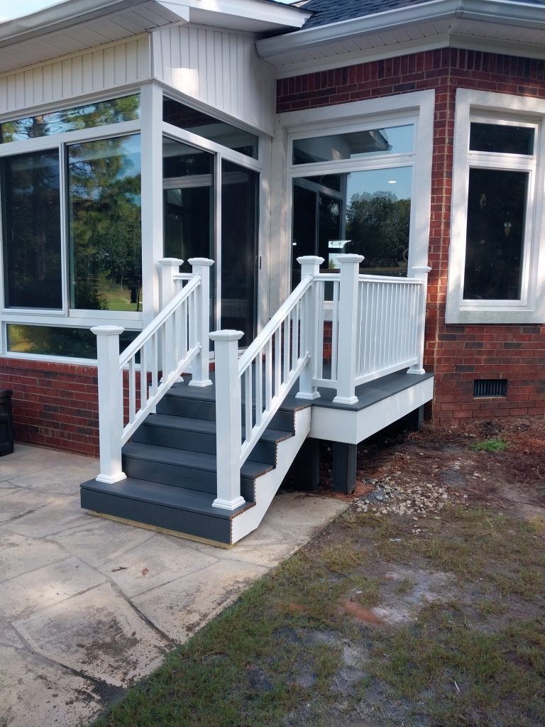Professional installation of white aluminum egress window systems and foundation covers on residential brick construction in Aiken SC.