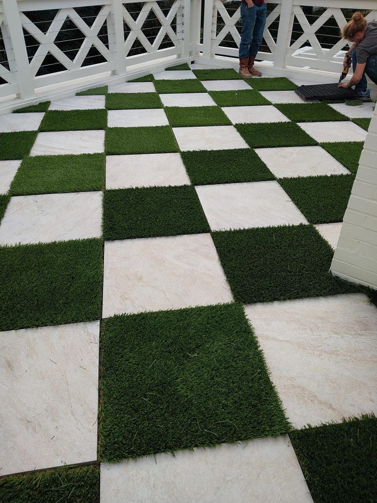 Professional installation of diamond-pattern hardscape featuring alternating artificial turf and stone pavers in Aiken.