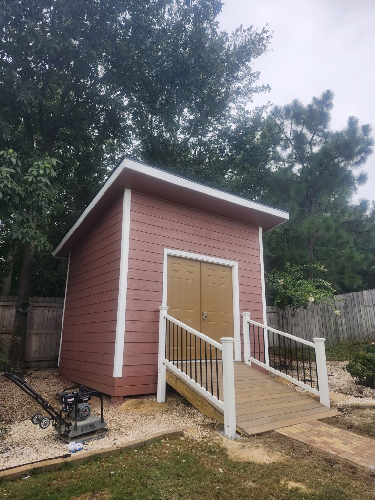 Residential home in Aiken SC featuring burgundy metal roofing and structural upgrades with professional construction equipment on-site.