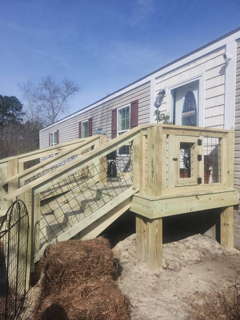 Timber-framed animal enclosure with metal mesh panels and wire fencing installed by construction professionals in Aiken.