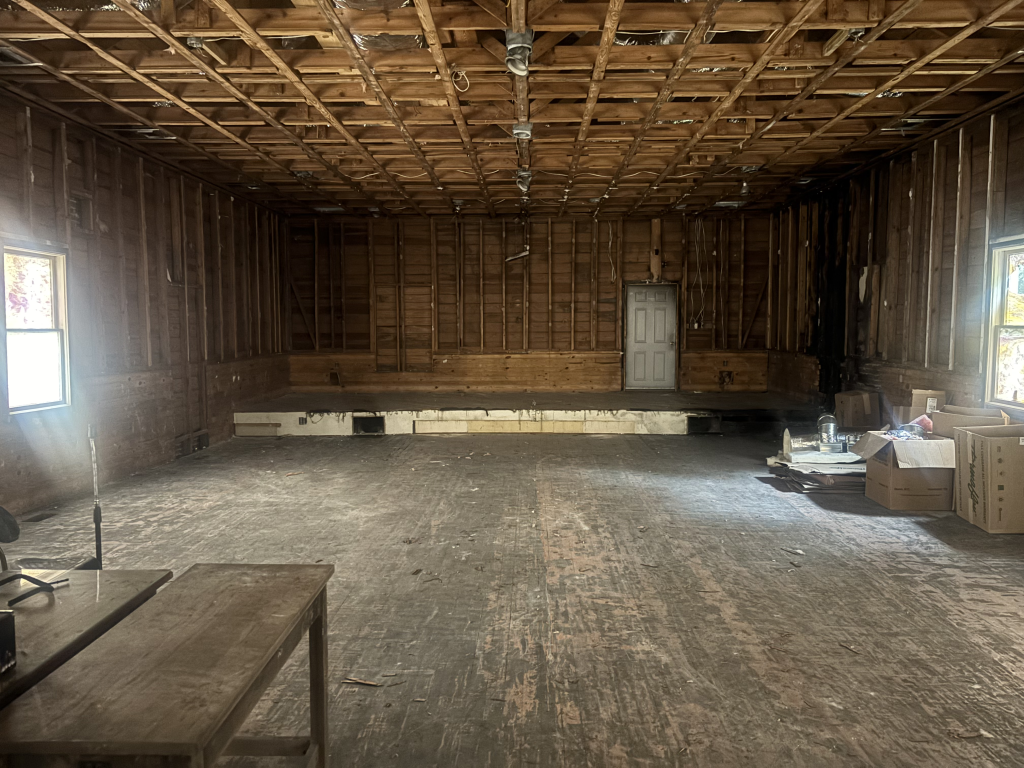 Residential interior framing stage showing exposed studs, ceiling joists, and partial drywall installation during active construction phase.