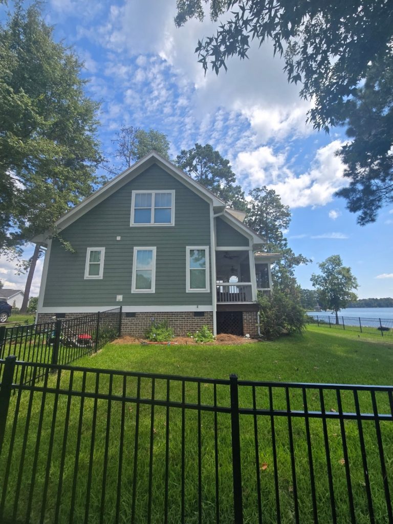 Modern residential home in Aiken SC featuring brick foundation, covered porch, and professional landscaping on waterfront lot.